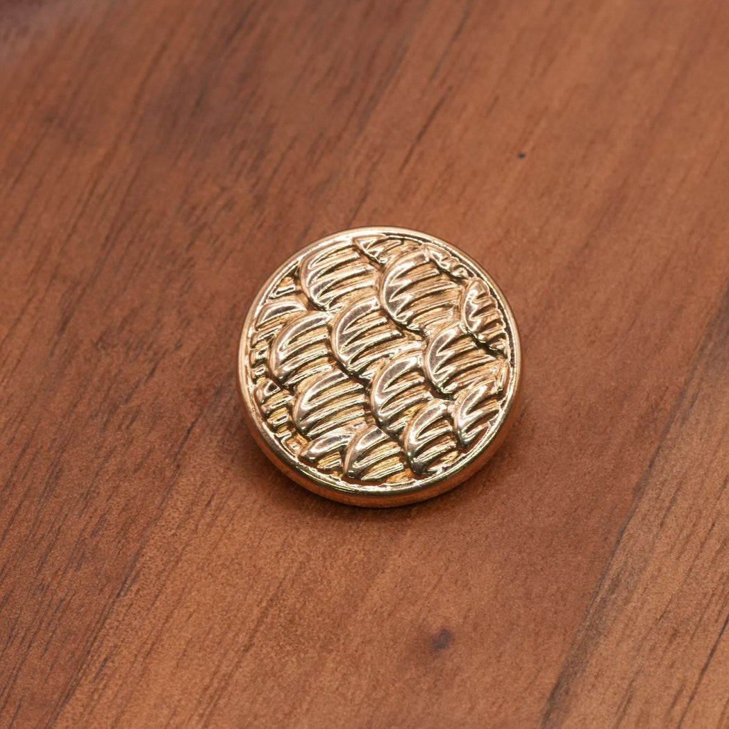 Gold finish round button with a ribbed scallop pattern, front view