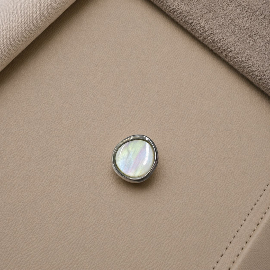 Silver-tone rimmed button with a light center and broad blue, pink and green bands