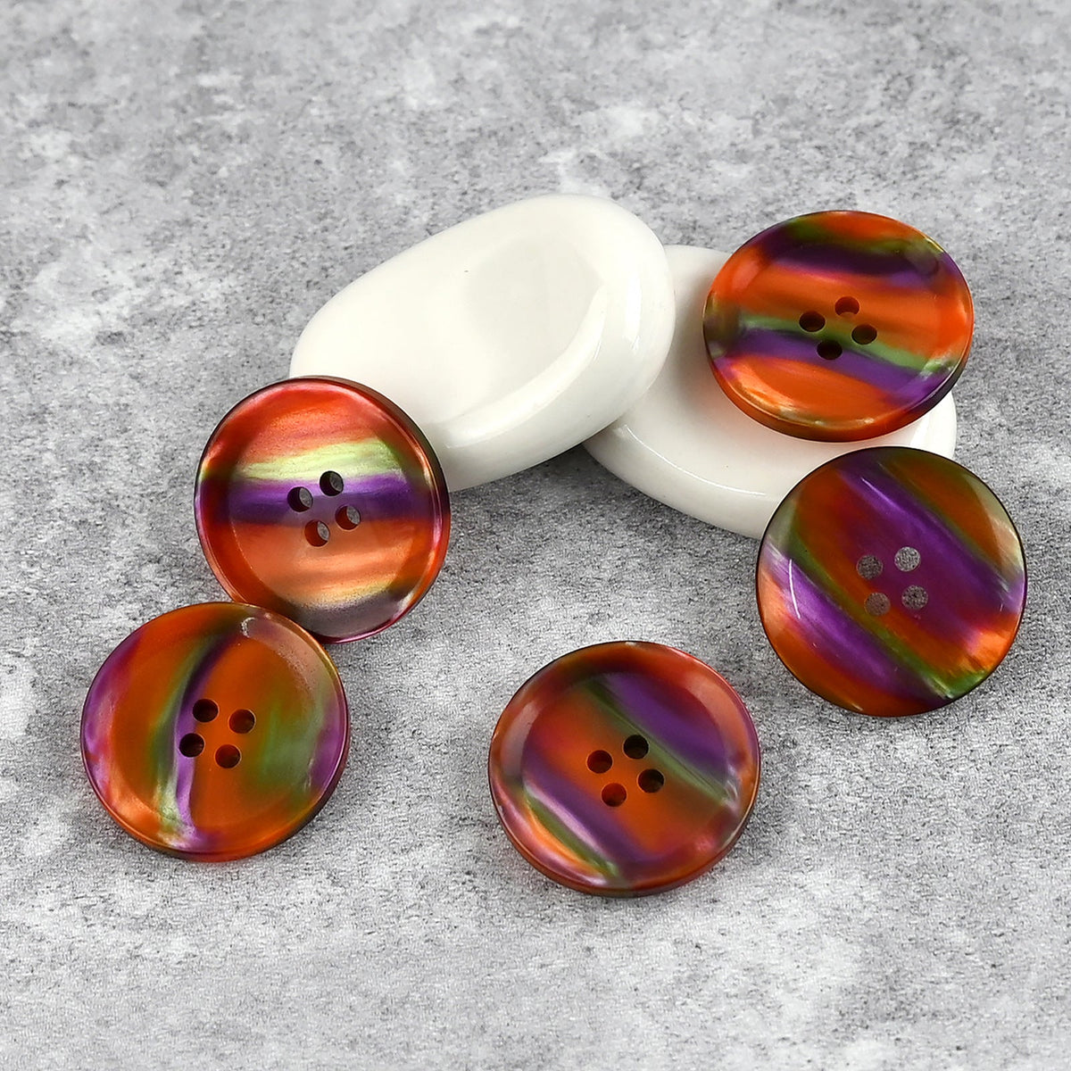 Orange, yellow, and purple iridescent buttons with broad color swirls