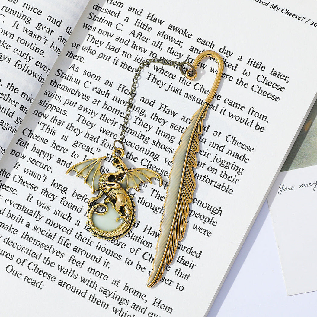 Gold dragon feather bookmark on an open book