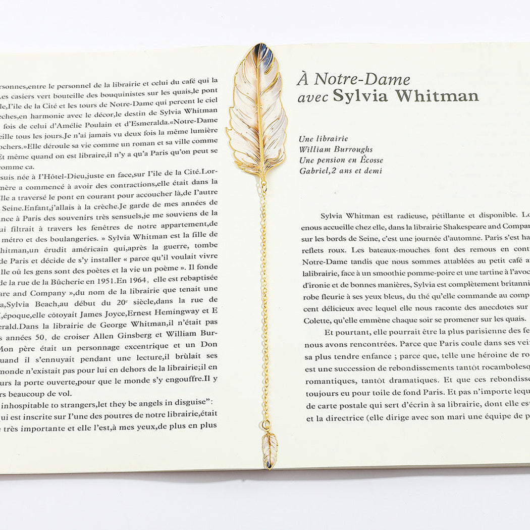 Feather bookmark resting on an open book