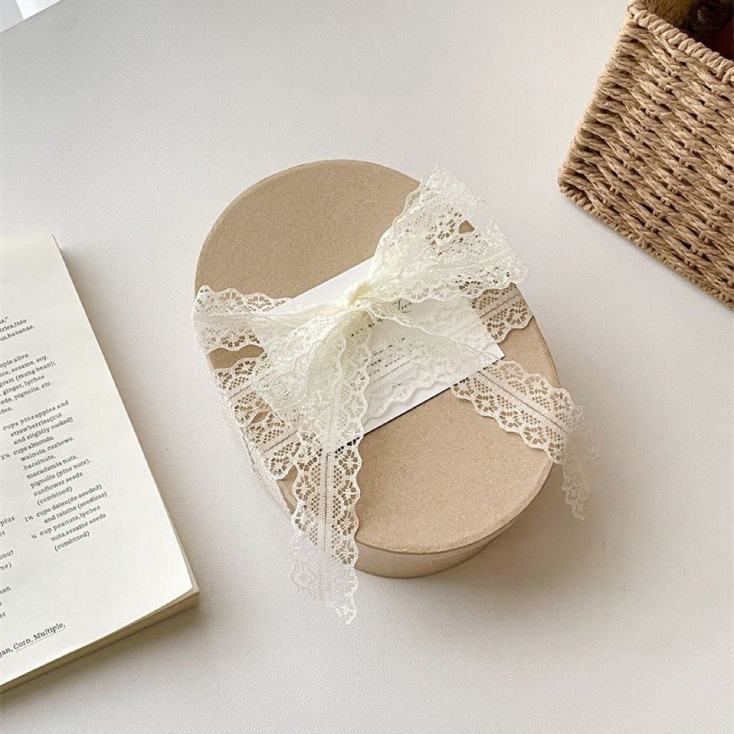 Off-white lace ribbon on a round gift box
