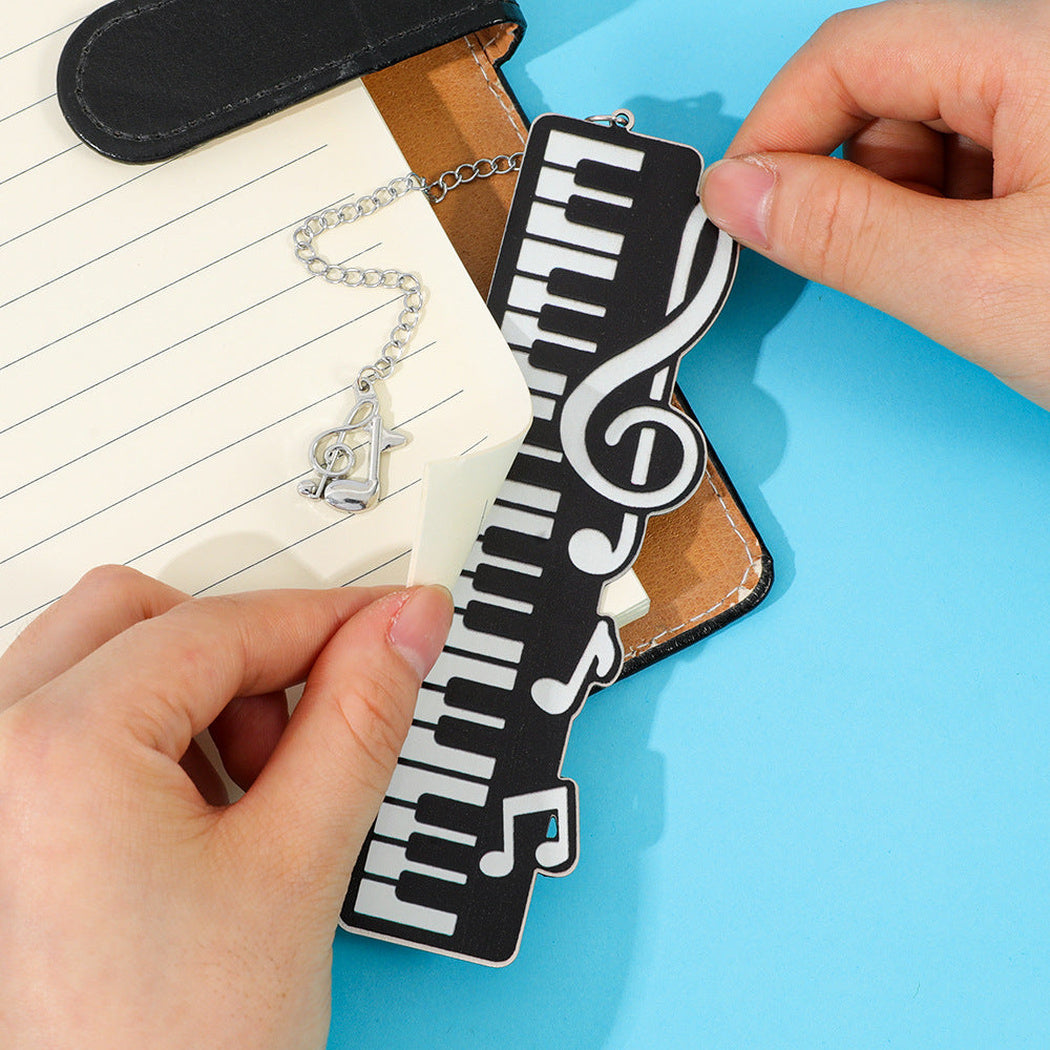 Hands placing the piano key bookmark on a page