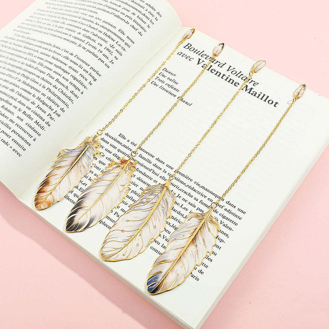 Four feather bookmarks beside open books