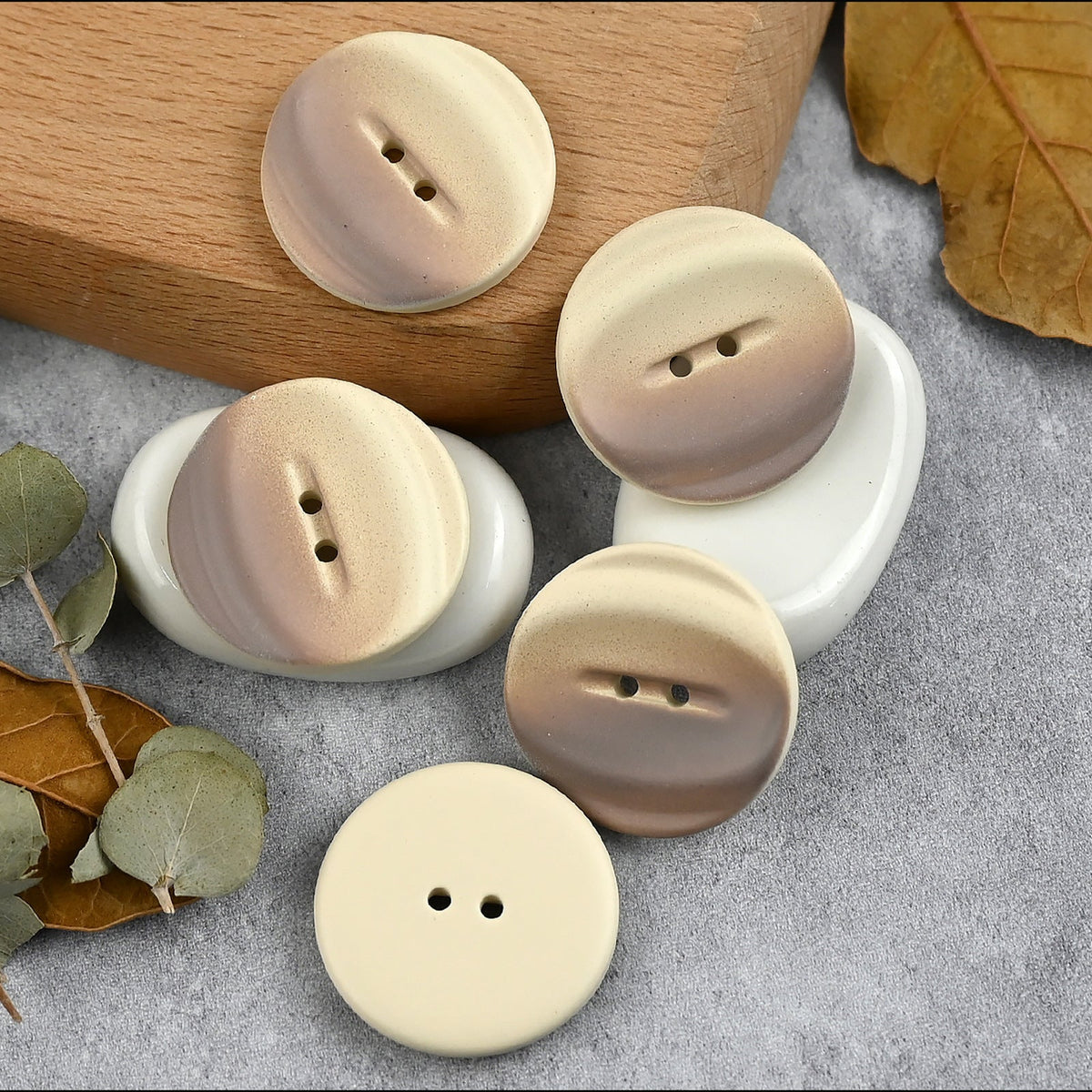 Light brown buttons with curved bands and flat reverse