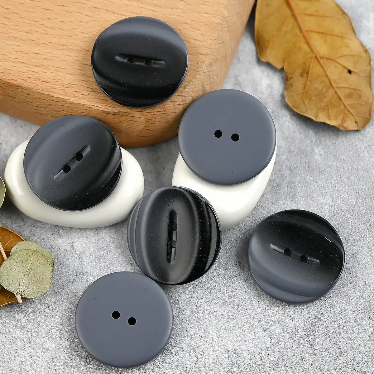 Black-gray buttons showing curved bands and flat backs