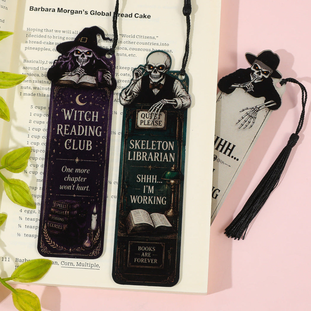 Three Halloween skeleton bookmarks displayed on an open book