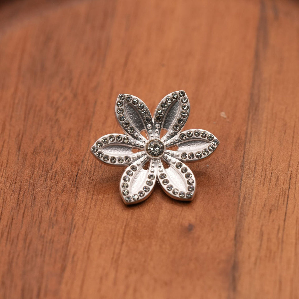 Silver-tone six-petal flower button with reflective border details