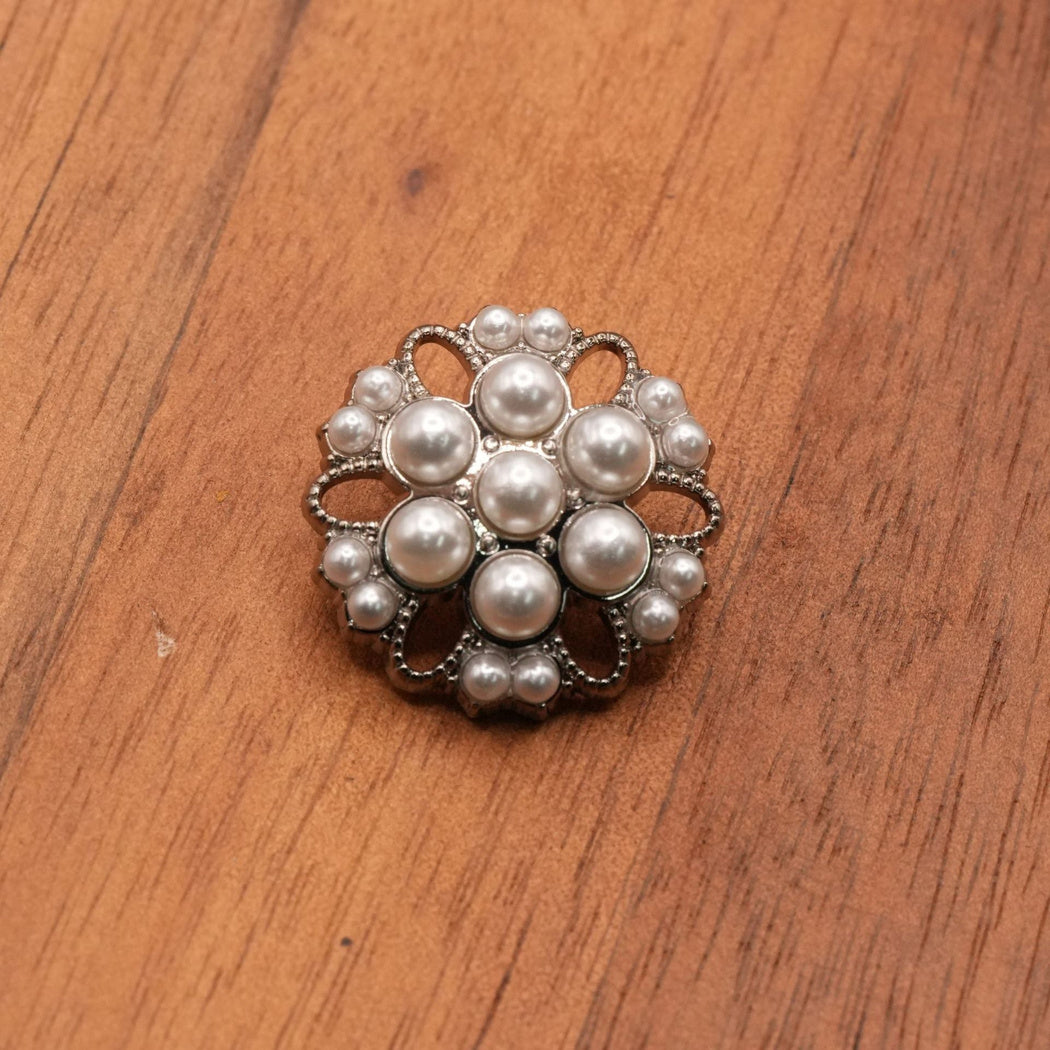Silver-tone open-petal flower button with white rounded insets, single front view