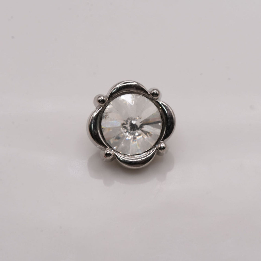 Silver-tone four-lobed button with rounded accents and clear faceted center