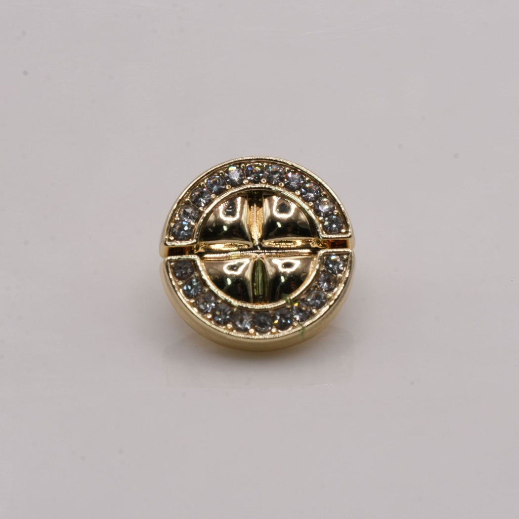Gold-tone segmented round button with clear outer arcs and raised center divisions