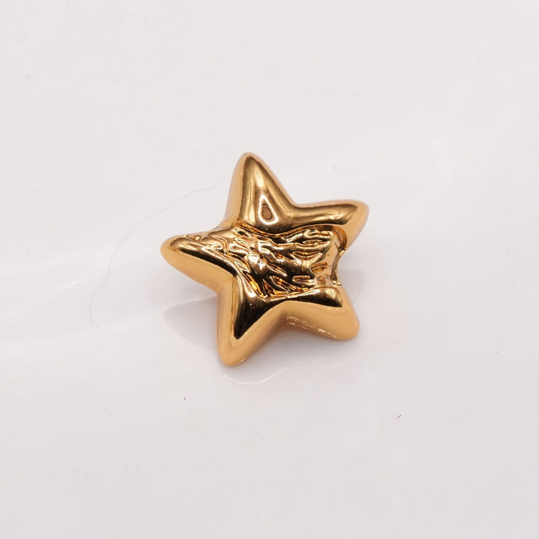 Warm gold tone star button with an irregular rippled center