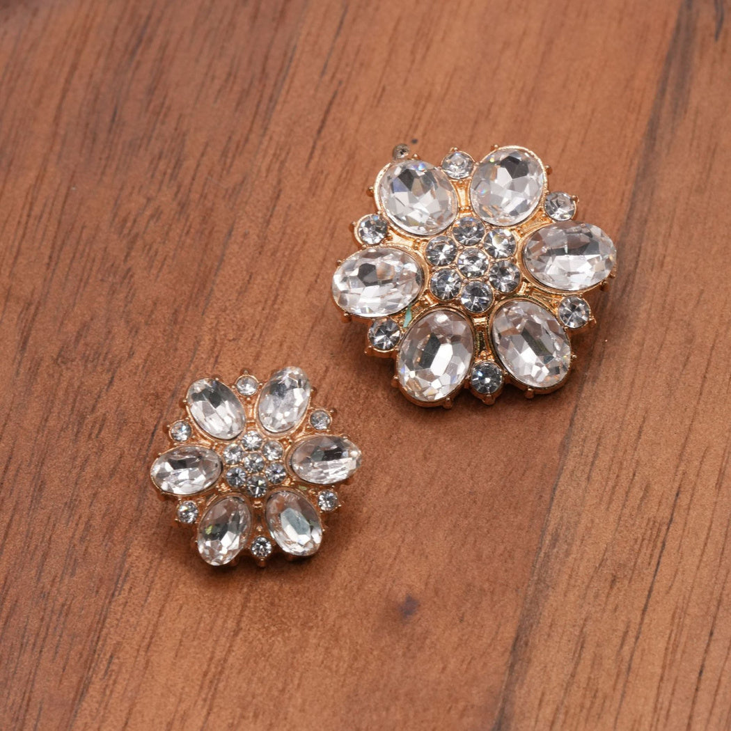Clear faceted flower button pair with gold-tone settings and oval petals