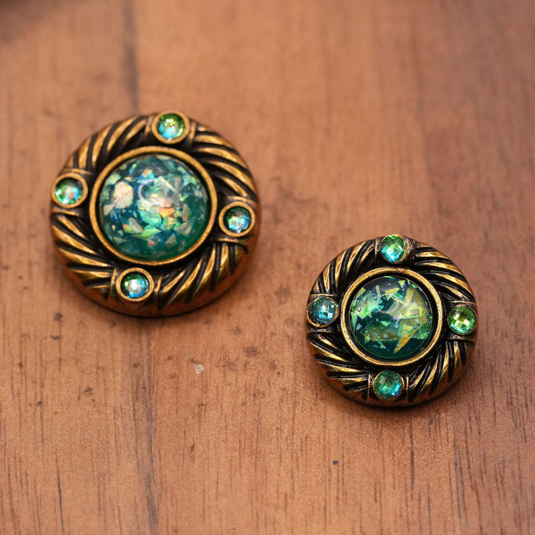 Two sizes of round buttons with green iridescent centers and four green accents