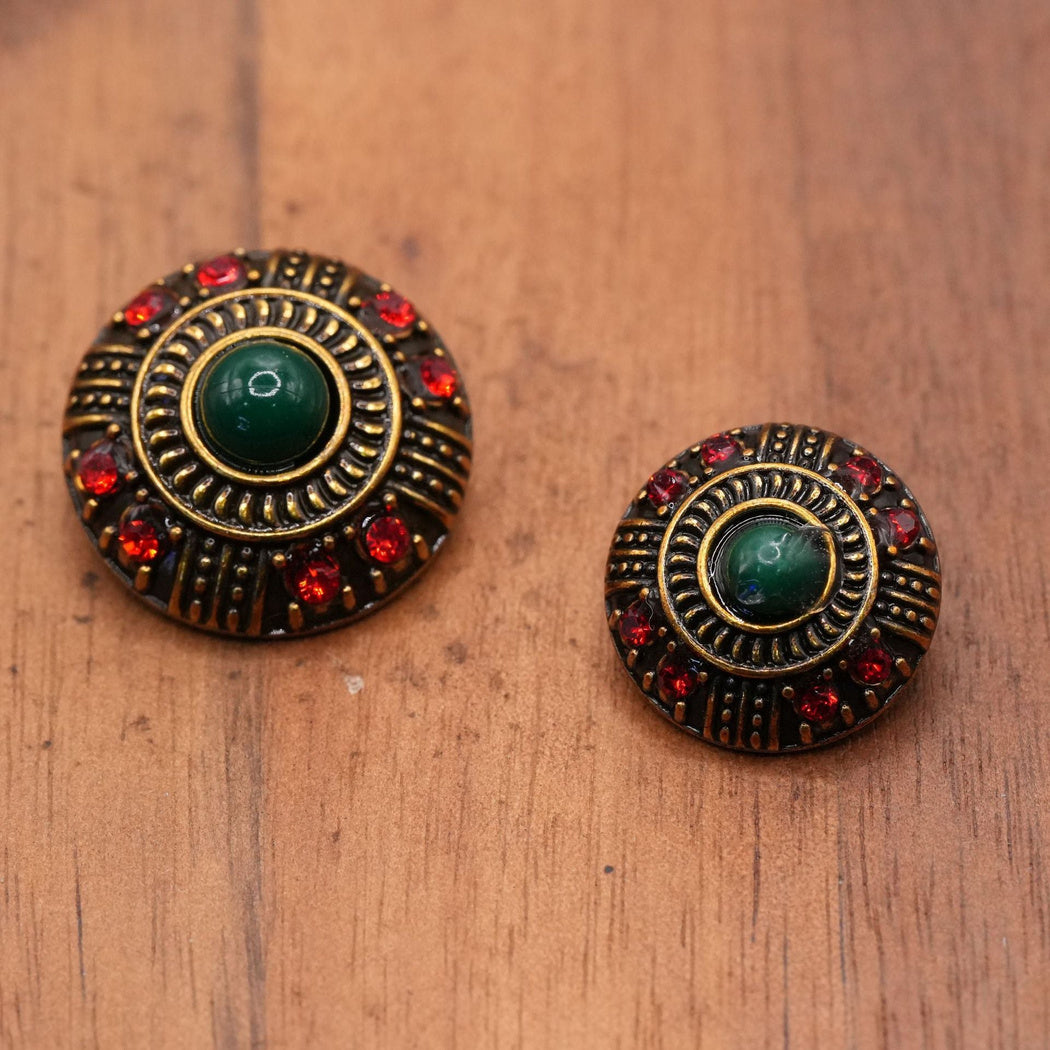 Two sizes of dark-green-center buttons with red accents and radial ridges
