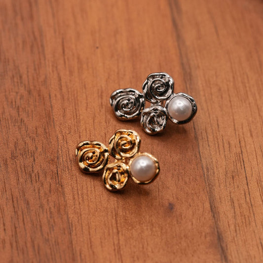Silver-colored and gold-colored four-lobed buttons with spiral details and pale domes