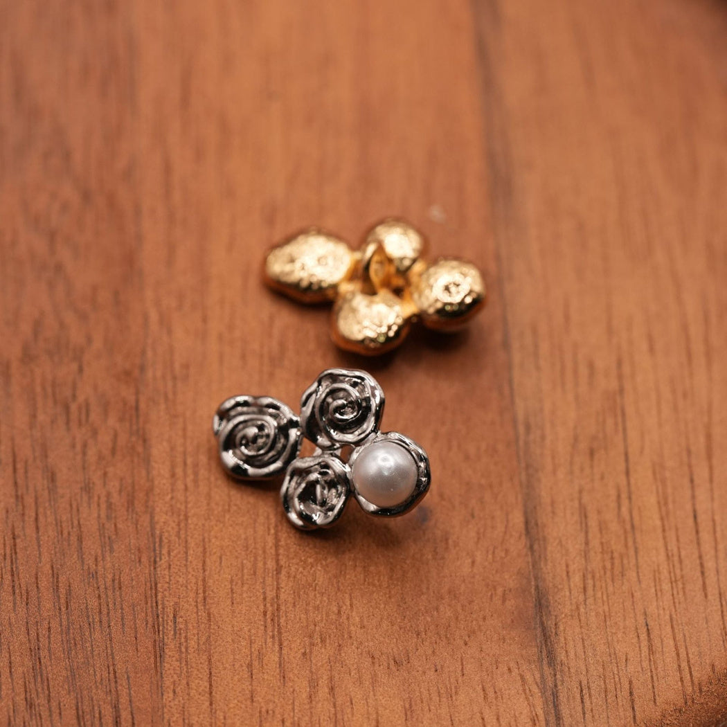 Silver-colored button front beside a gold-colored button back with a central sewing loop
