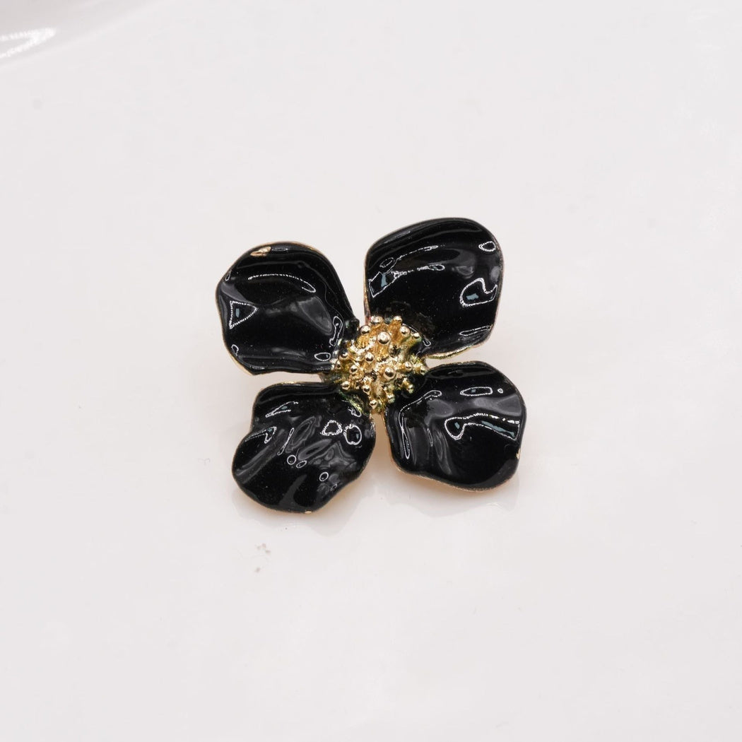 Black four-petal flower button with gold-tone edges and a dotted center