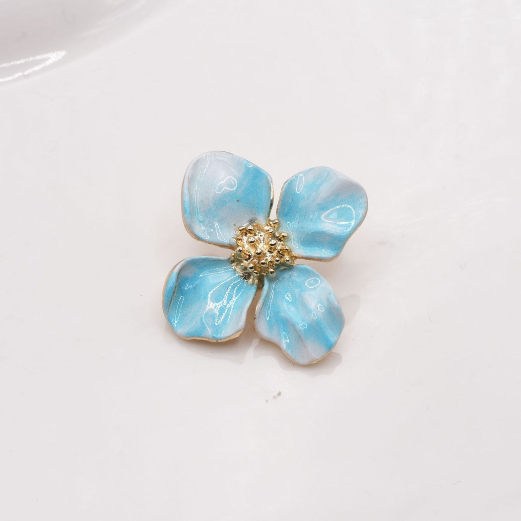 Blue and white four-petal flower button with gold-tone edges, front view