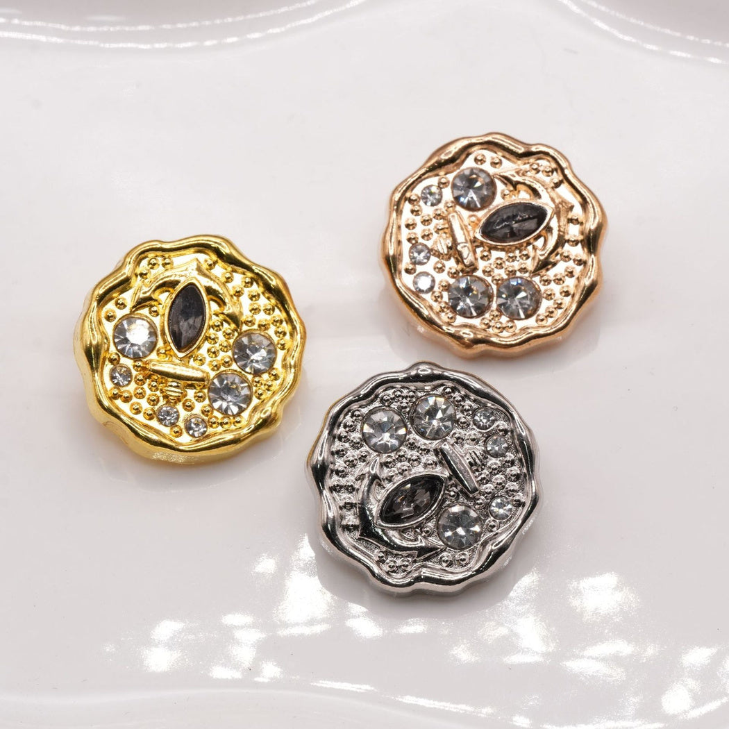 Scalloped button faces in three color finishes with raised anchor details.