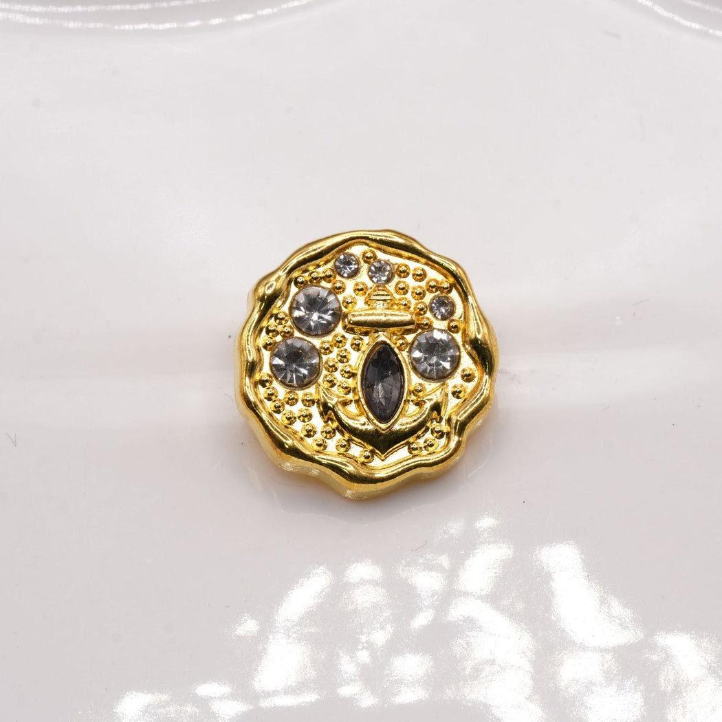 Yellow-gold-tone scalloped button face with a raised anchor and round accents.