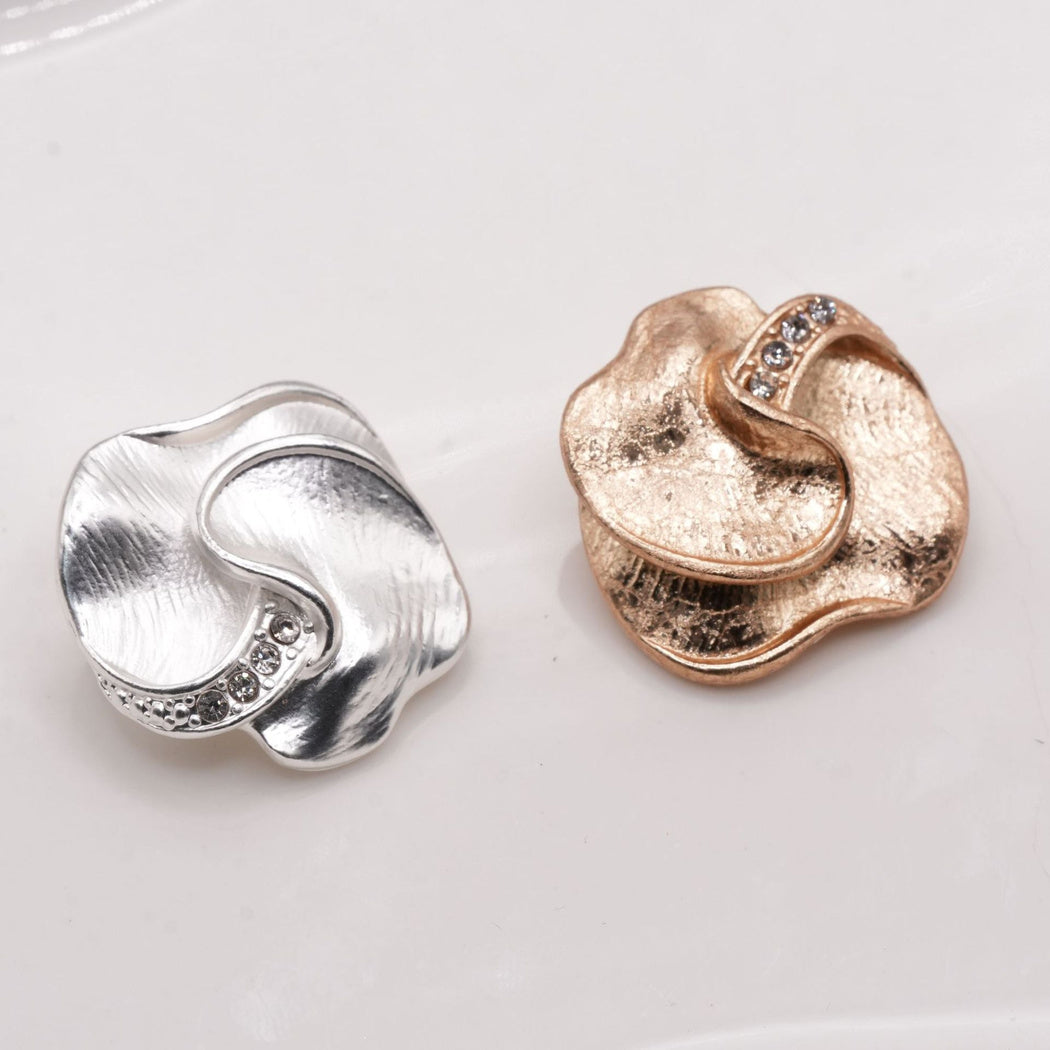 Silver and gold tone lobed buttons with curved ridges, front views