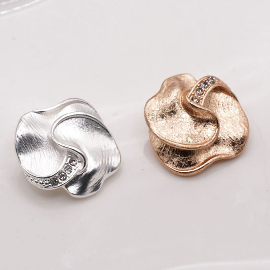 Silver and gold tone lobed buttons with curved ridges, front views