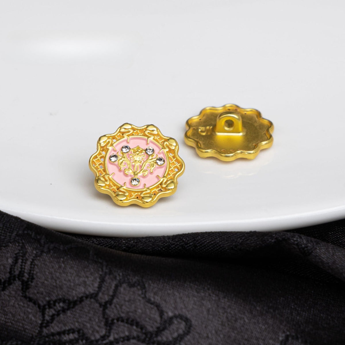 Ornate pink floral shank button front and back on white plate