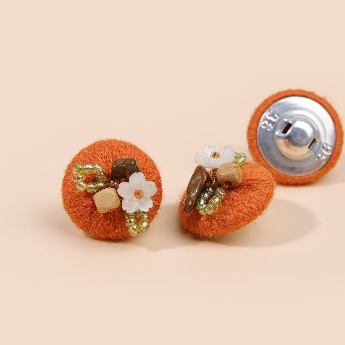 Warm orange beaded floral round button from three views
