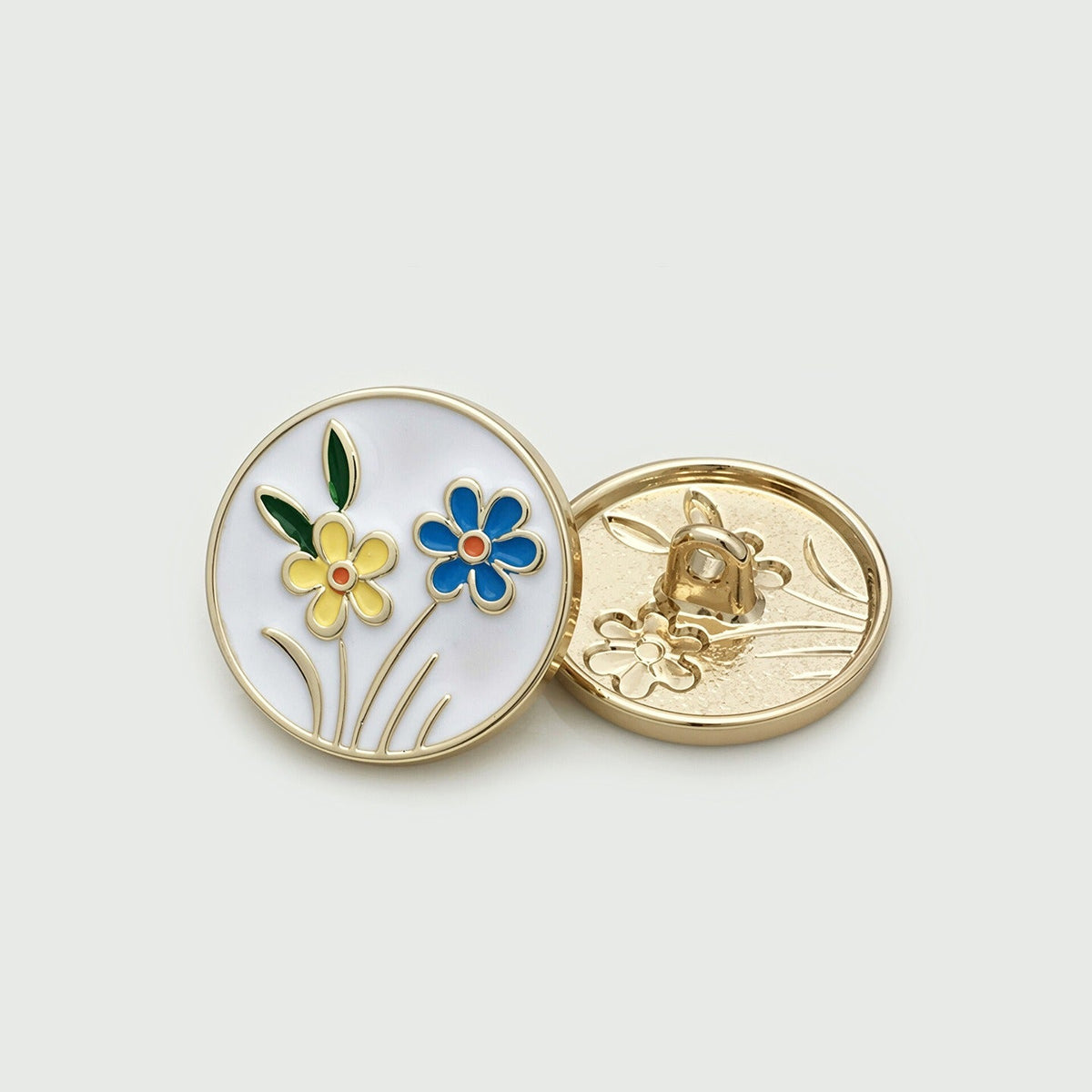 White round button with blue and yellow flower motif, shown front and back