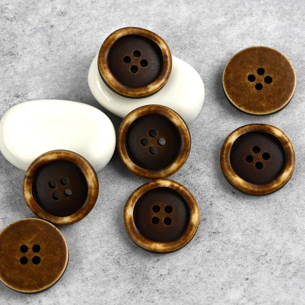 Deep brown four-hole buttons with raised wavy outer rings