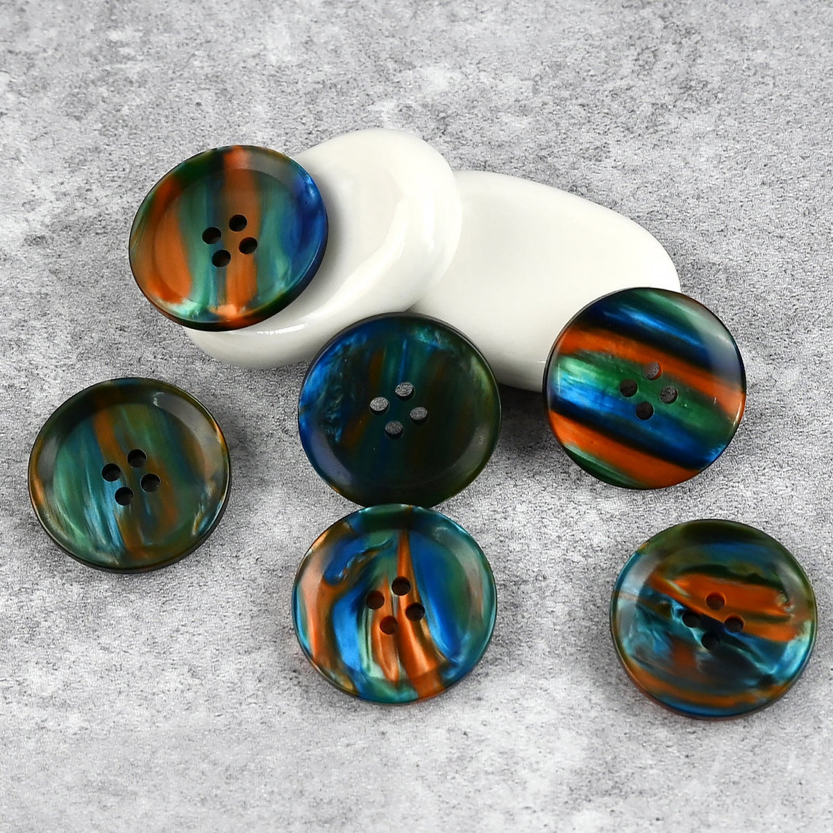 Green, blue, and orange iridescent buttons with flowing color bands