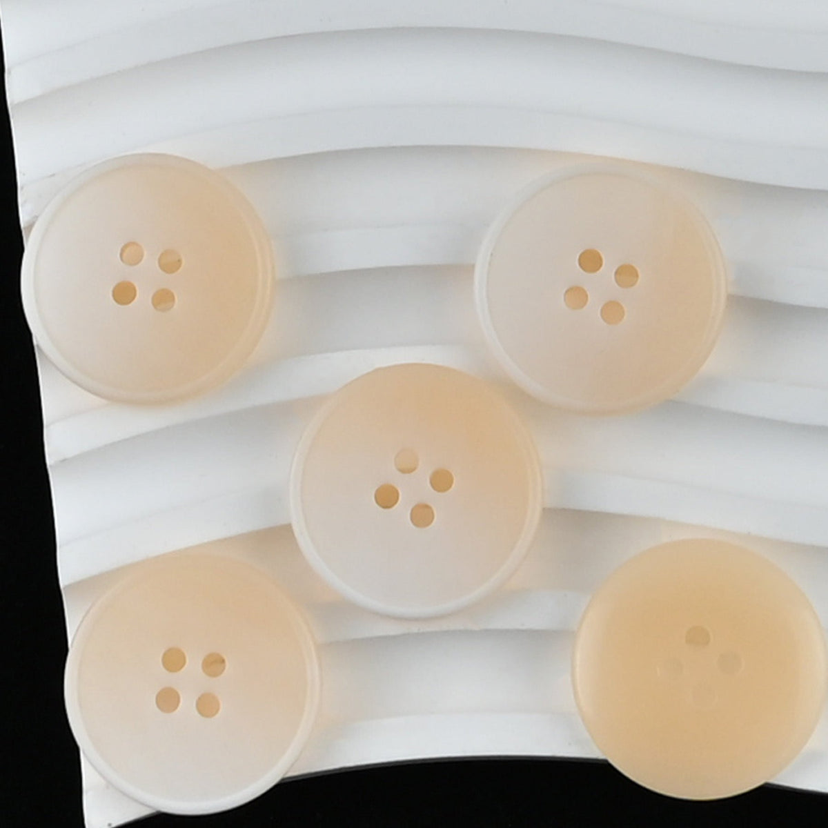 Beige four-hole buttons with subtle streaked faces