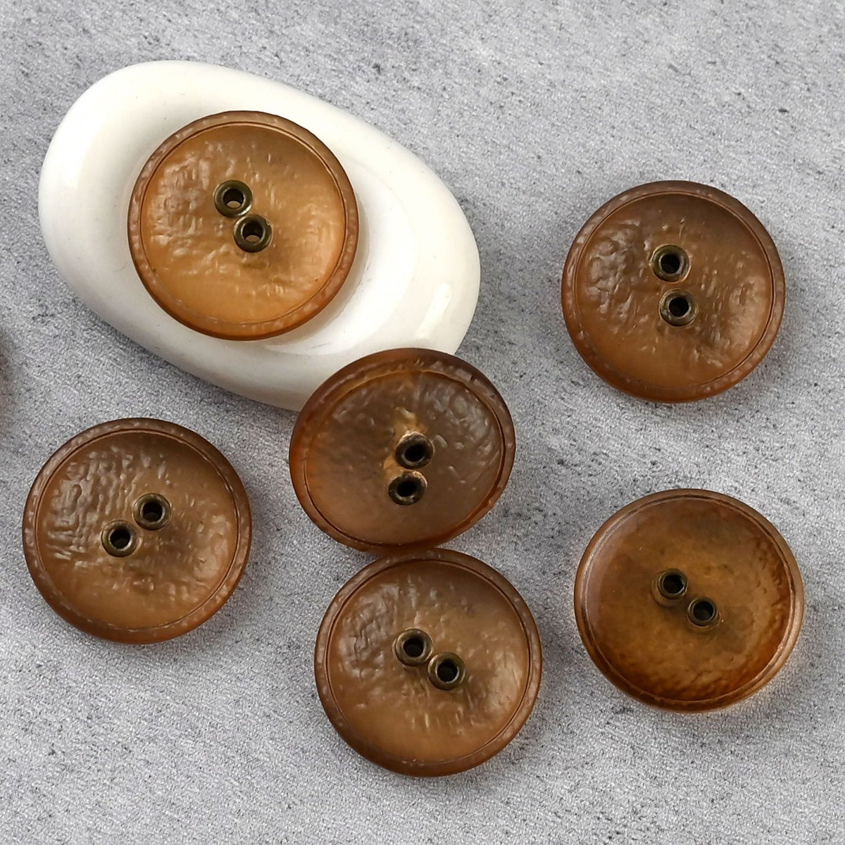 Amber two-hole textured buttons with warm-toned eyelets