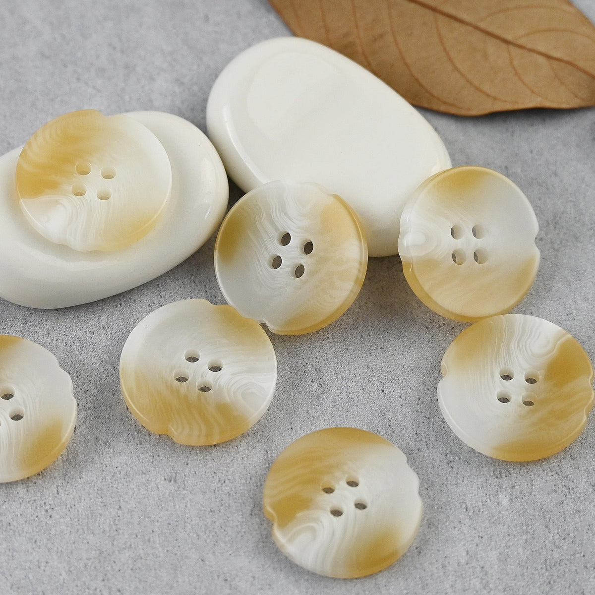 Cream four-hole buttons with notched edges and pale swirl patterns
