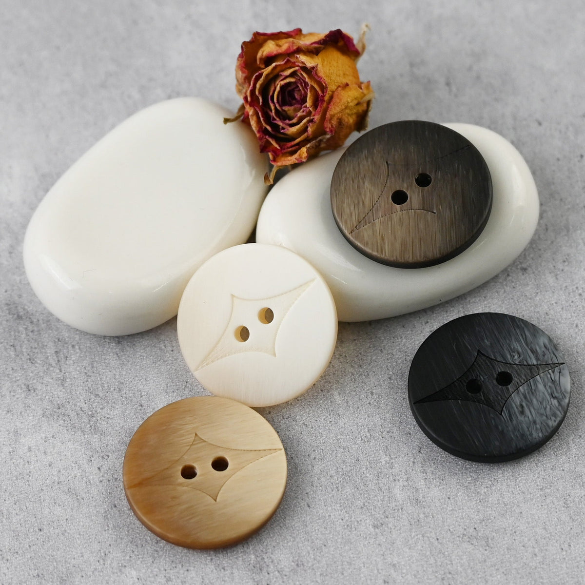 Cream, brown, and black round two-hole buttons with curved center insets