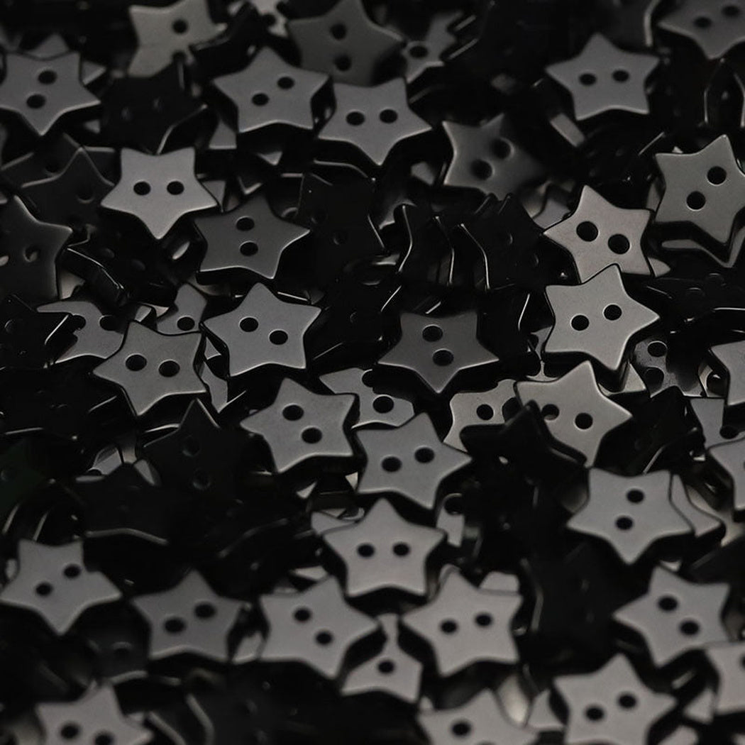Close-up pile of black five-point star two-hole buttons