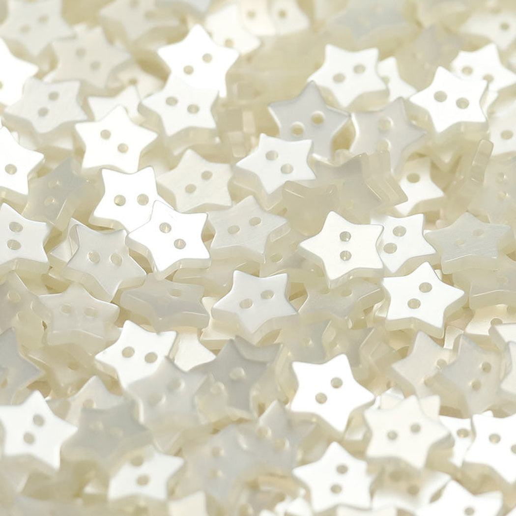 Close-up pile of white five-point star two-hole buttons