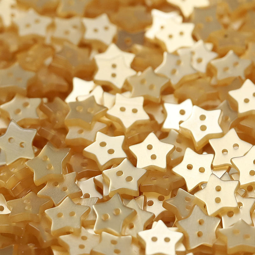 Close-up pile of beige five-point star two-hole buttons