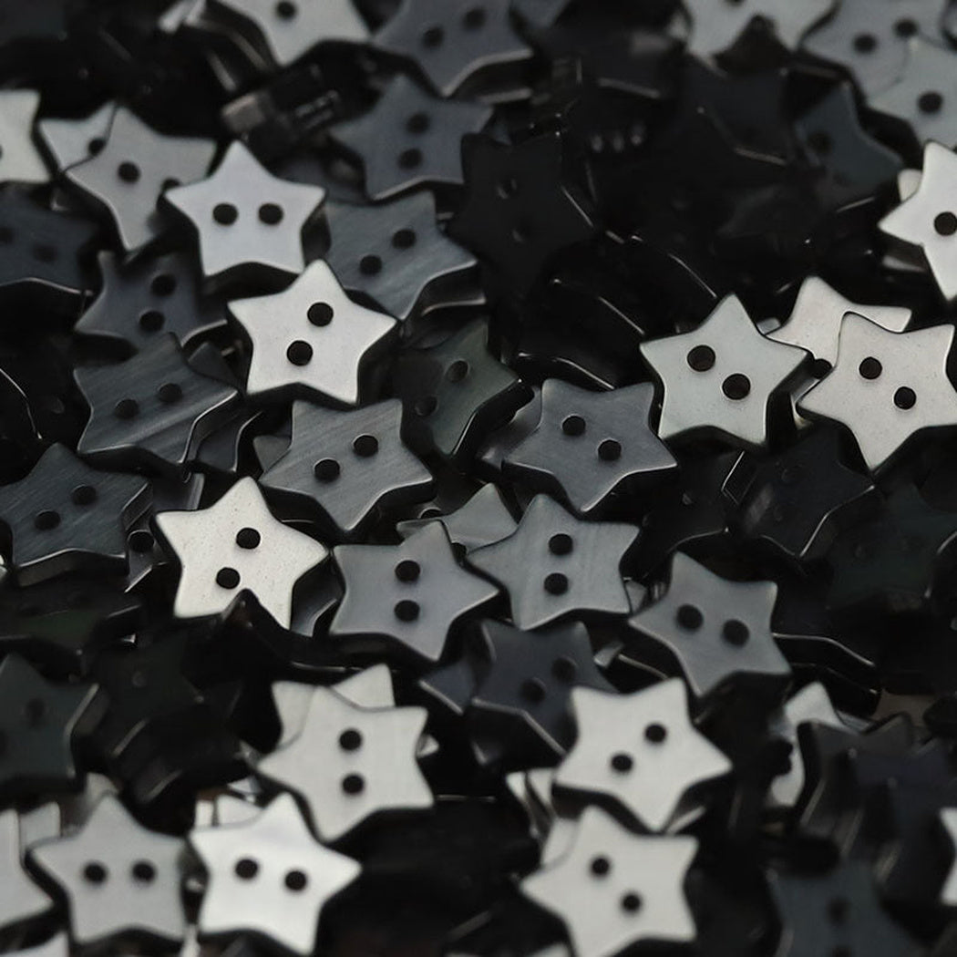 Close-up pile of charcoal five-point star two-hole buttons