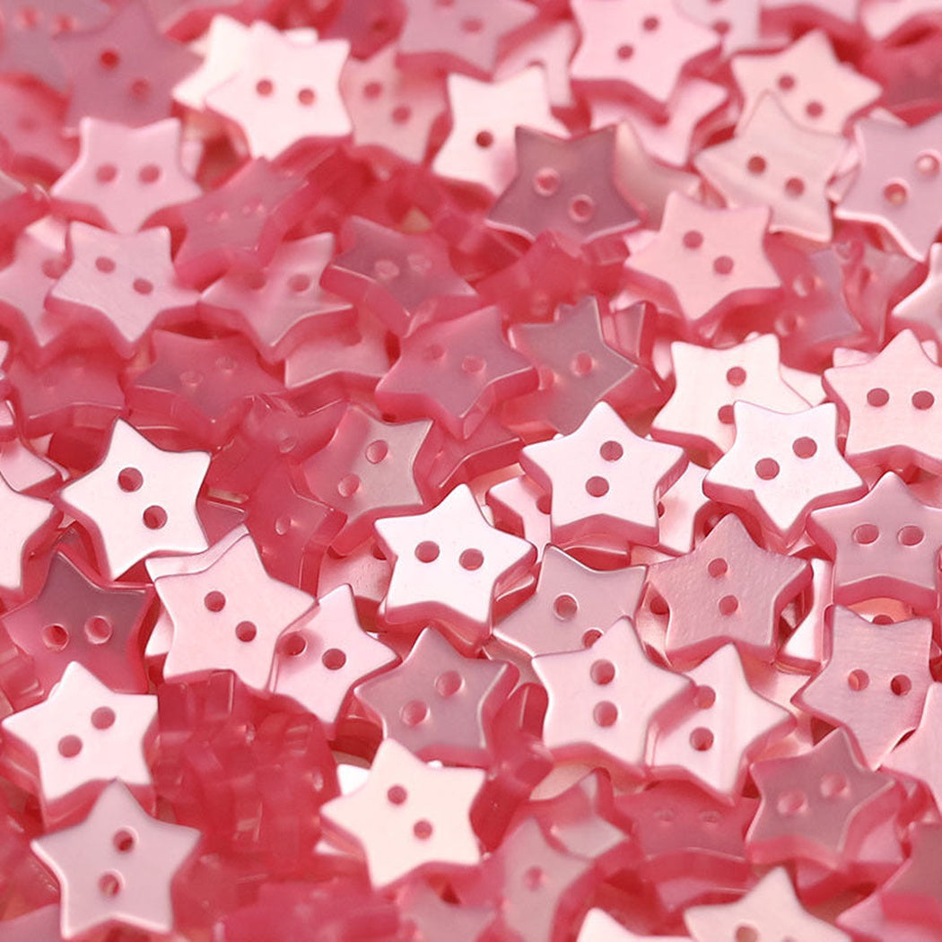 Close-up pile of deep pink five-point star two-hole buttons