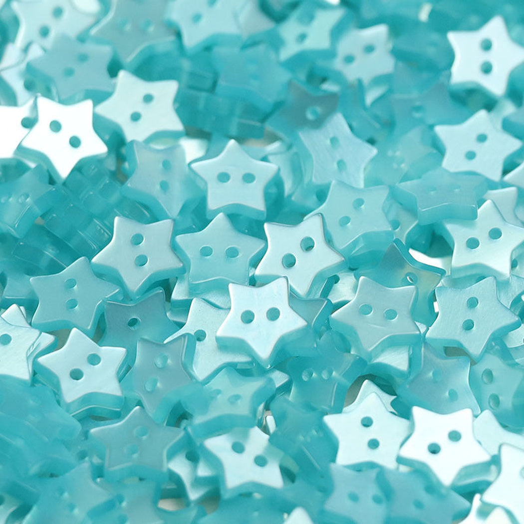 Close-up pile of aqua five-point star two-hole buttons
