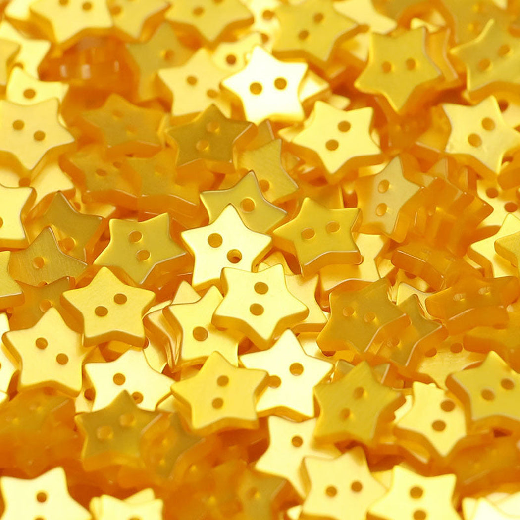 Close-up pile of yellow five-point star two-hole buttons