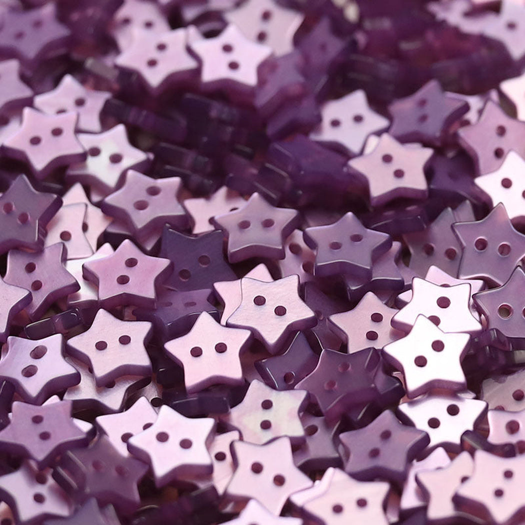 Close-up pile of purple five-point star two-hole buttons