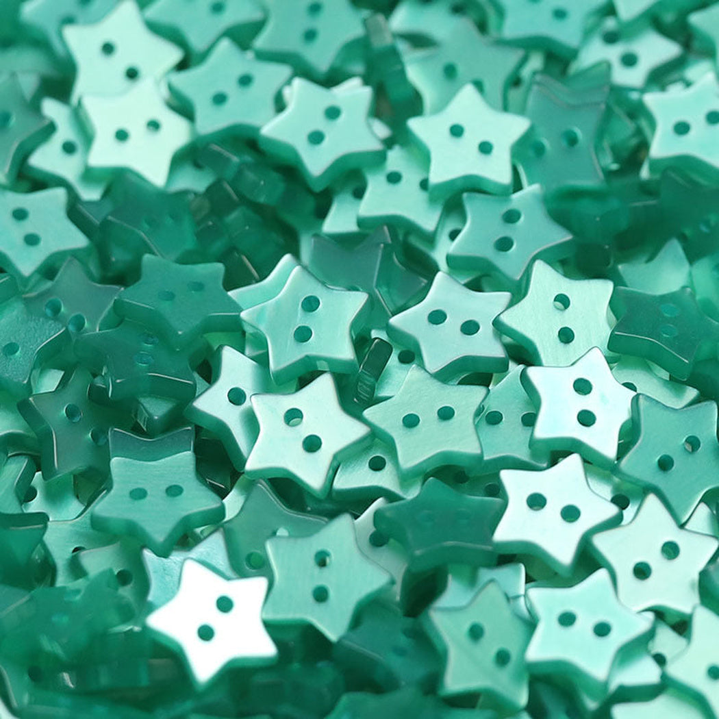 Close-up pile of teal five-point star two-hole buttons