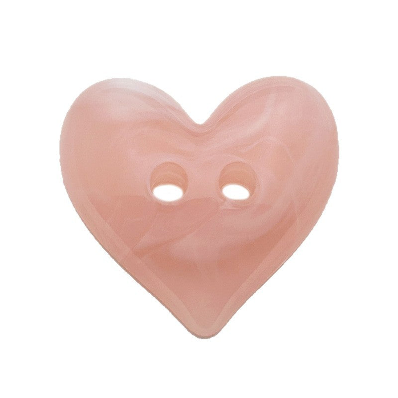 Pink swirled heart-shaped button in close front view