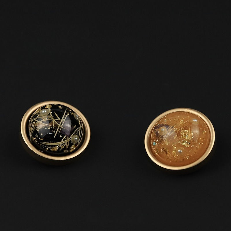 Black and orange round flecked buttons shown together