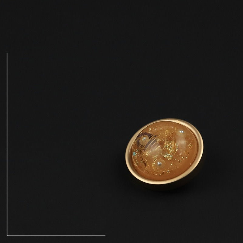 Orange flecked button with narrow rim viewed at an angle