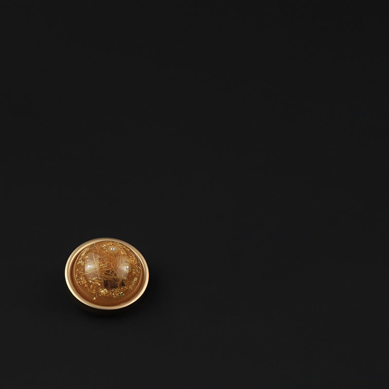 Orange round domed button front view on dark background